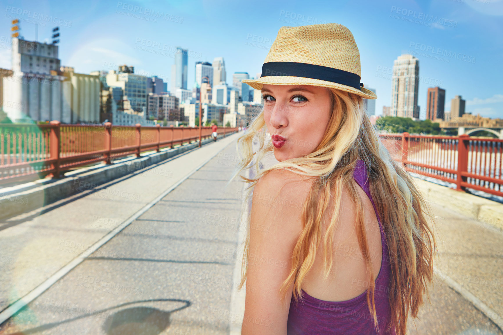 Buy stock photo Shot of a smiling young woman walking around the city in the summertime