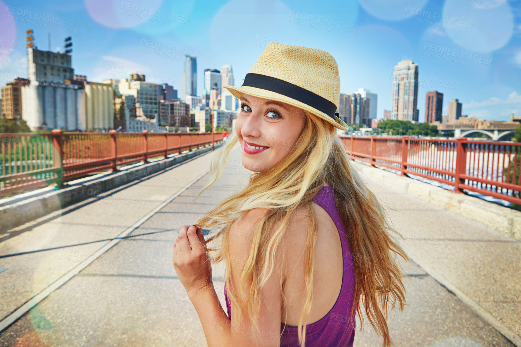 Buy stock photo Shot of a smiling young woman walking around the city in the summertime