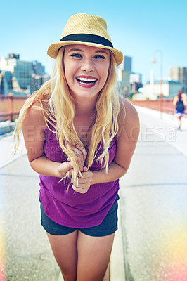 Buy stock photo Shot of a smiling young woman walking around the city in the summertime