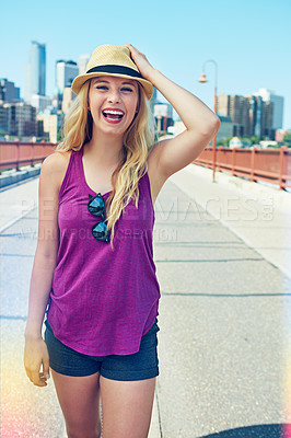 Buy stock photo Shot of a smiling young woman walking around the city in the summertime