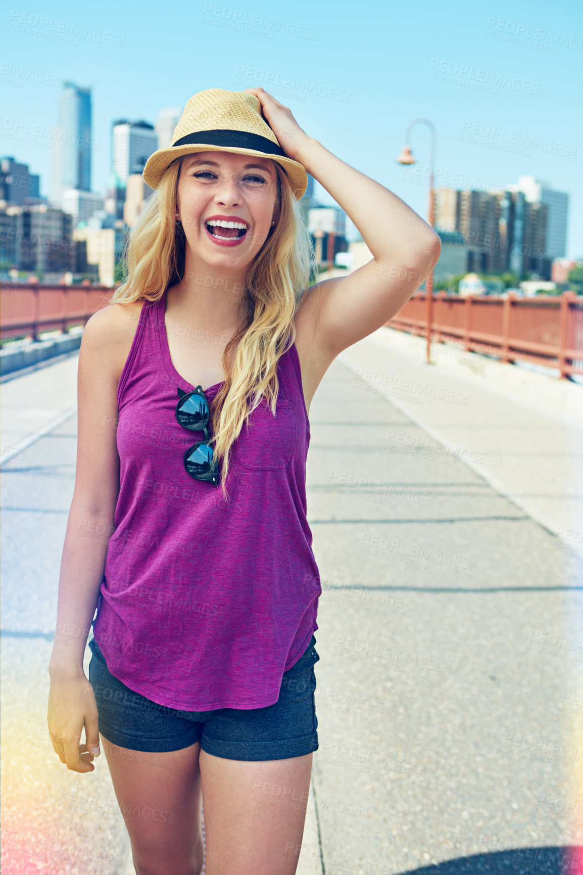 Buy stock photo Shot of a smiling young woman walking around the city in the summertime