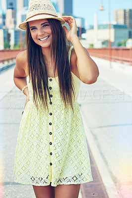 Buy stock photo Shot of a smiling young woman walking around the city in the summertime