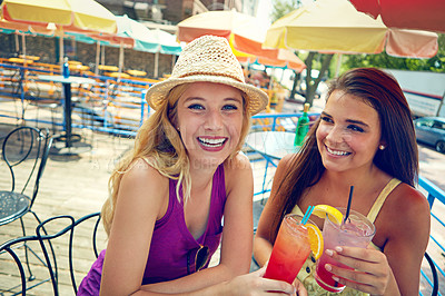 Buy stock photo Shot of two attractive young women sitting at an outdoor cafe