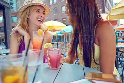 Buy stock photo Shot of two attractive young women sitting at an outdoor cafe