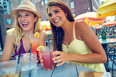 Buy stock photo Shot of two attractive young women sitting at an outdoor cafe