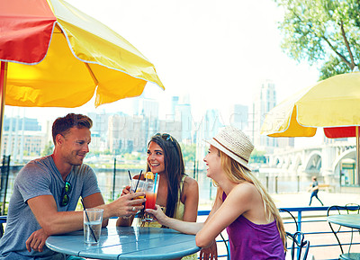 Buy stock photo Shot of three young friends sitting at an outdoor cafe