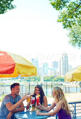 Buy stock photo Shot of three young friends sitting at an outdoor cafe