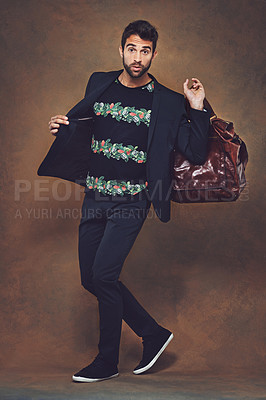 Buy stock photo Man, fashion and stylish outfit in studio on brown background, confident male person, model and trendy bag in hand. Leather luggage, businessman and travel abroad for work and business clothes