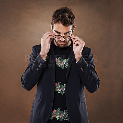 Buy stock photo Glasses, fashion and man in studio with blazer for classy, stylish and trendy outfit with confidence. Spectacles, serious and male person with elegant and fancy style isolated by brown background.
