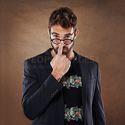 Buy stock photo Glasses, fashion and portrait of man in studio with blazer for classy, stylish and trendy outfit with confidence. Spectacles, serious and male person with elegant and fancy style by brown background.