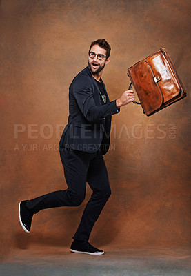 Buy stock photo Briefcase, fashion and man in studio with glasses for trendy, edgy and stylish outfit with confidence. Goofy, satchel and person with blazer for classy style running for comedy by brown background.