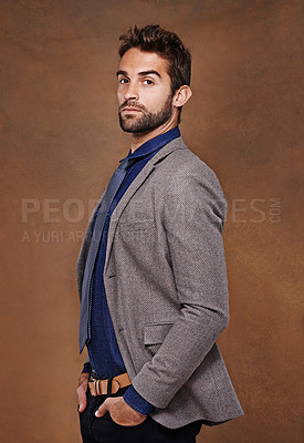 Buy stock photo Serious, fashion and portrait of man in studio for trendy, edgy and stylish outfit with confidence. Pride, face and male person with blazer for classy, elegant or fancy style by brown background.