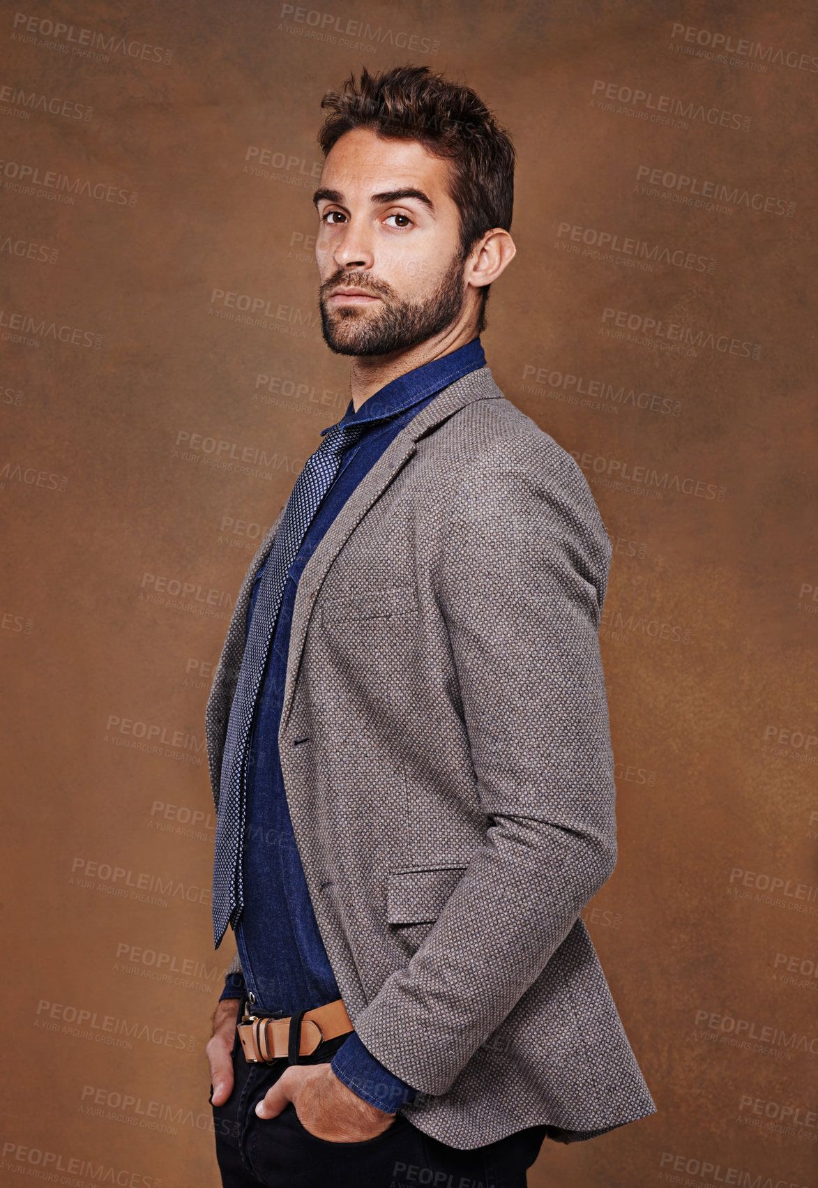 Buy stock photo Serious, fashion and portrait of man in studio for trendy, edgy and stylish outfit with confidence. Pride, face and male person with blazer for classy, elegant or fancy style by brown background.