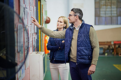 Buy stock photo People, business and planning schedule with board in warehouse with calendar for order details. Man, woman and together for checking for supplier information or notes, inventory updates and targets.
