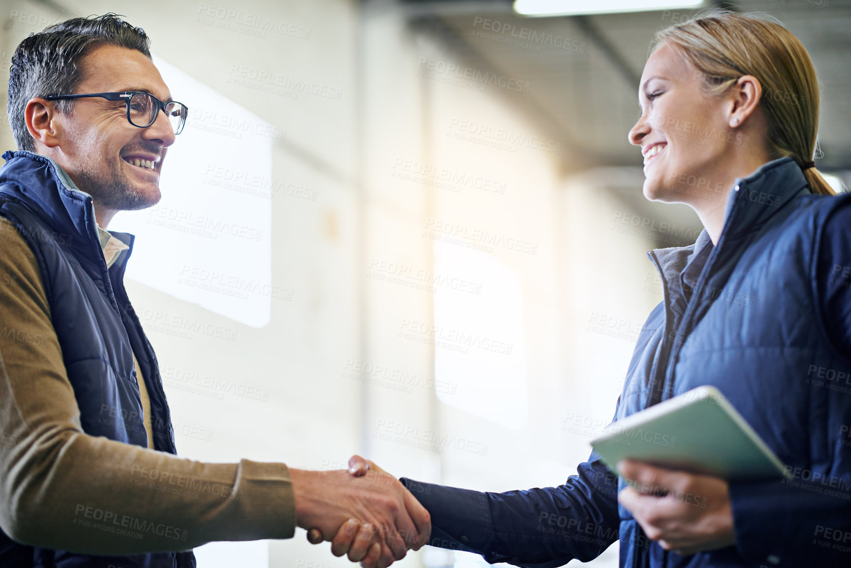 Buy stock photo Handshake, welcome and business people for collaboration, partnership or agreement on deal. Lens flare, tablet and shaking hands for export support, b2b meeting or distribution in shipping factory