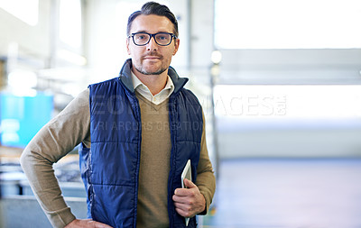 Buy stock photo Portrait of a manager holding a digital tablet while standing on the factory floor