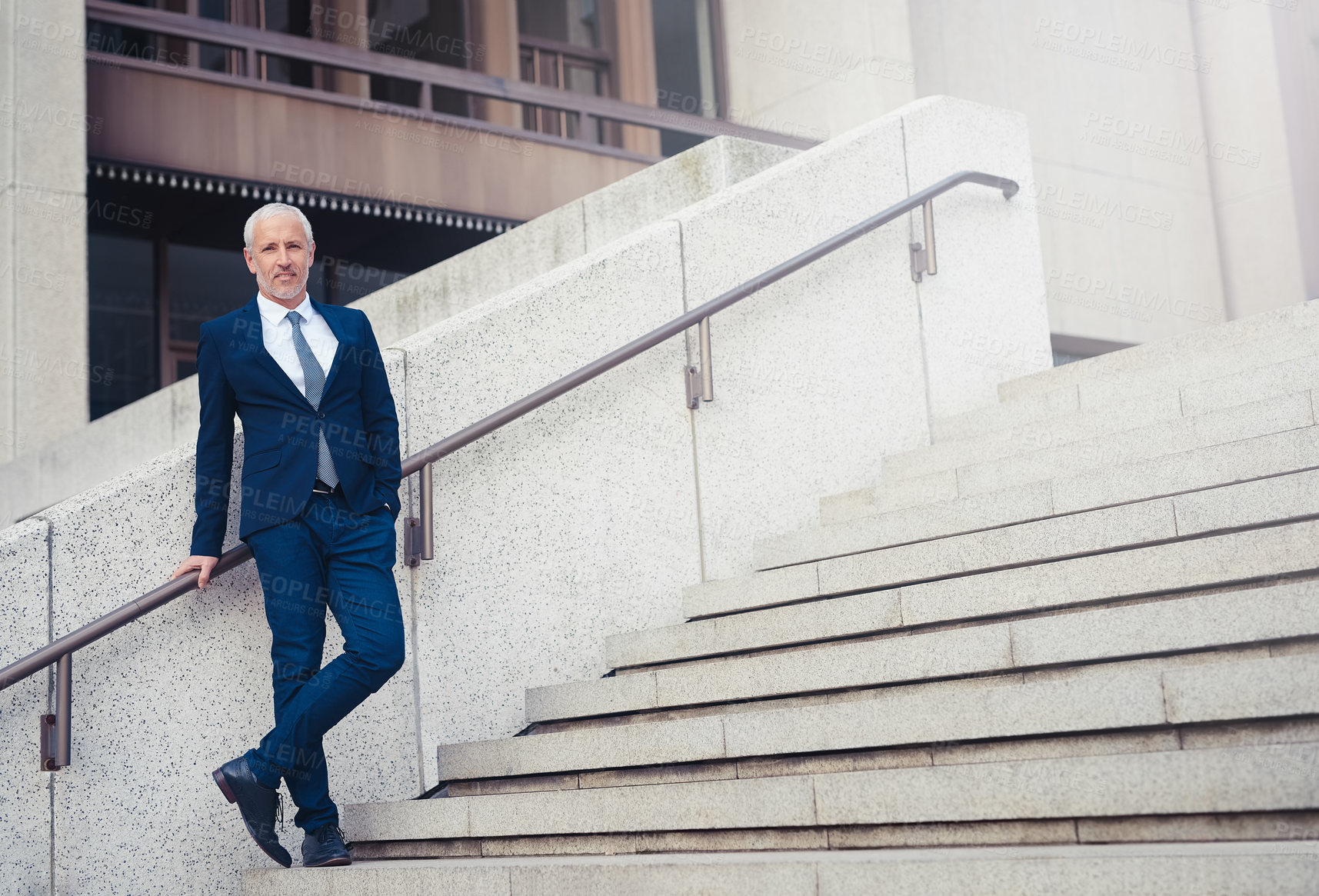 Buy stock photo Shot of a confident businessman standing outside his office building in the city