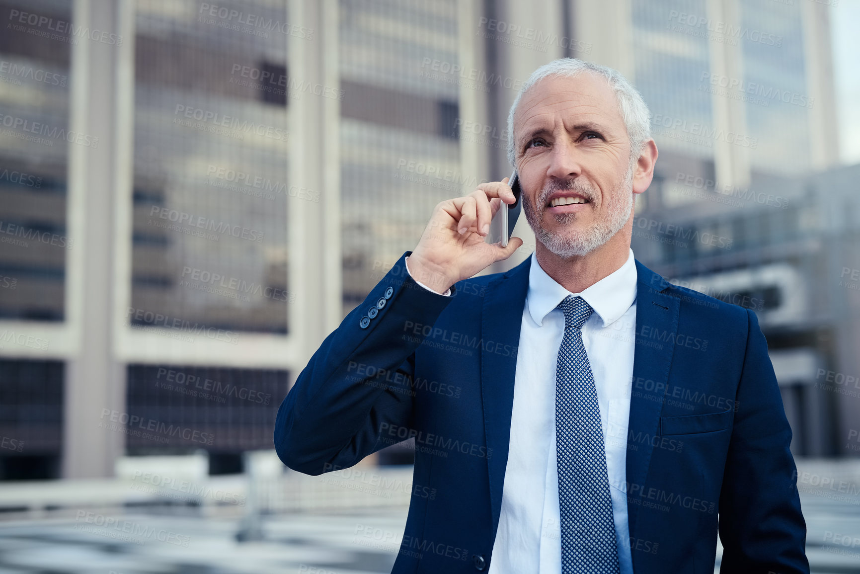 Buy stock photo Shot of a businessman answering his phone while walking to his office in the city