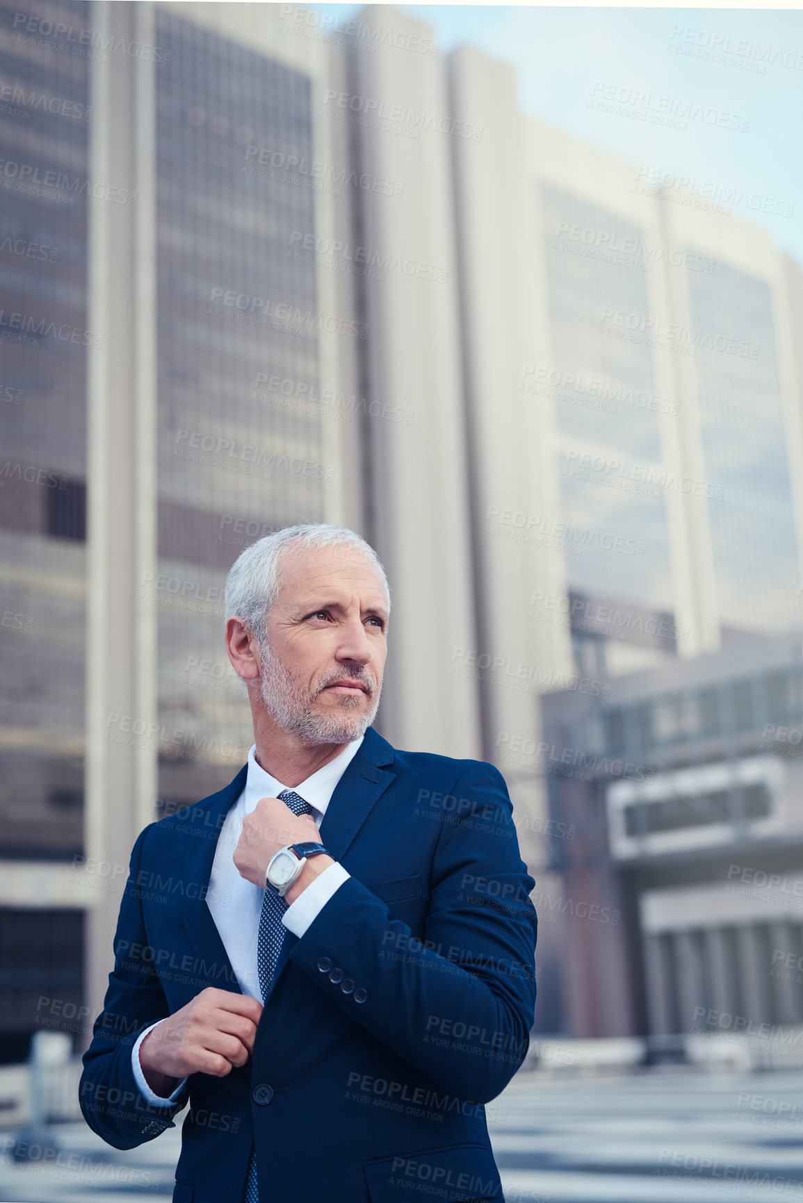 Buy stock photo Shot of a confident businessman standing outside his office building in the city