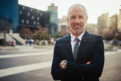 Buy stock photo Portrait of a confident businessman standing in an urban landscape