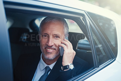 Buy stock photo Shot of a businessman answering his cellphone while sitting in his car