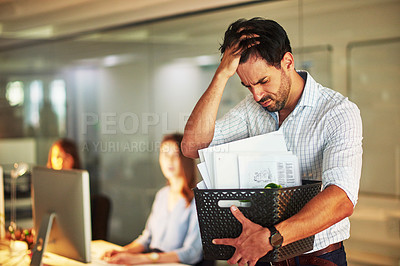 Buy stock photo Shot of a stressed businessman holding his box of possessions after getting fired from his job
