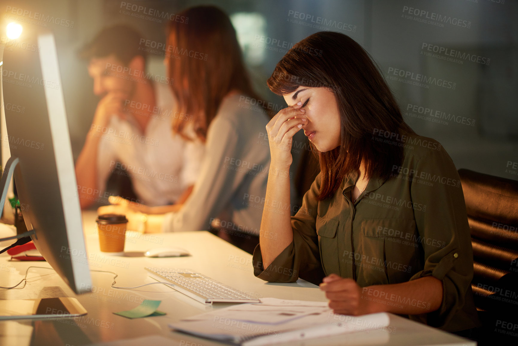 Buy stock photo Woman, copywriter and headache in working late, burnout and tired in office with coworkers, desktop and notebook. Female person, creative and fatigue on tech for deadline, publication or magazine