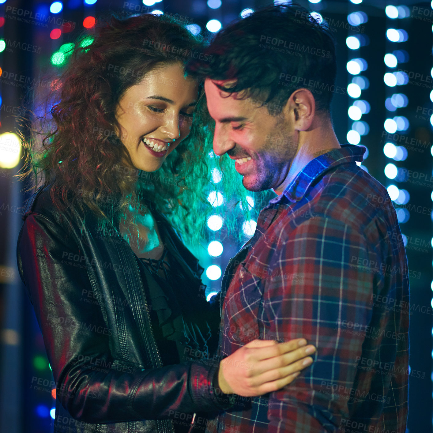 Buy stock photo Shot of an affectionate young couple dancing together in a nightclub