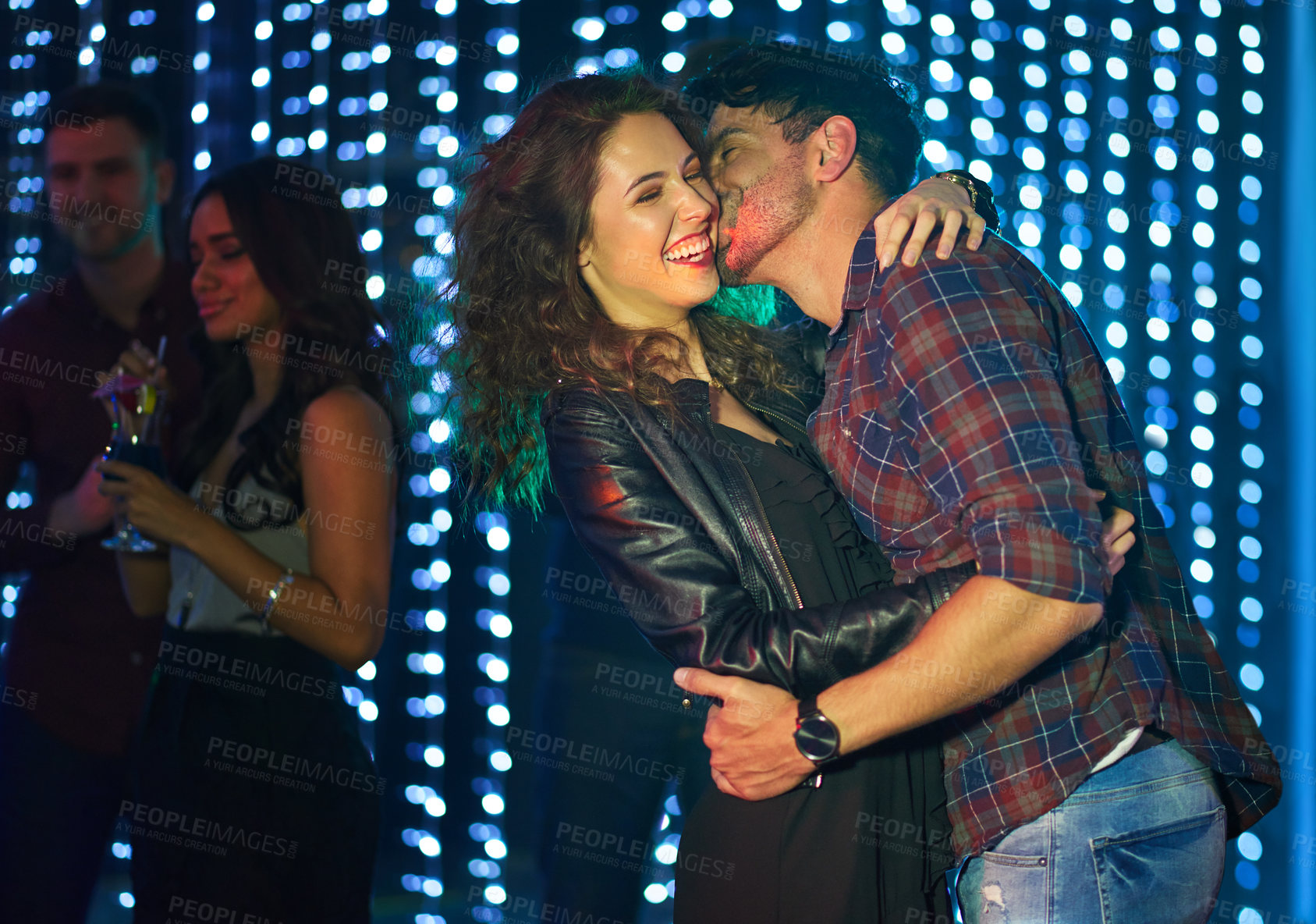 Buy stock photo Shot of an affectionate young couple dancing together in a nightclub