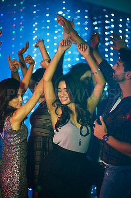 Buy stock photo Shot of a group of young people having fun on the dancefloor in a nightclub