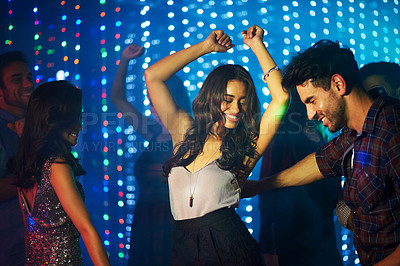 Buy stock photo Shot of a group of young people having fun on the dancefloor in a nightclub