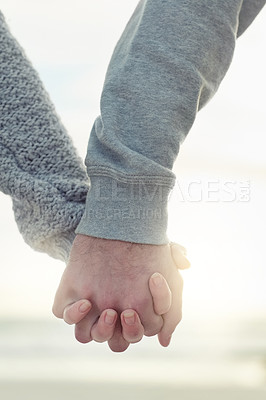 Buy stock photo Shot of an unidentifiable couple holding hands while walking outside