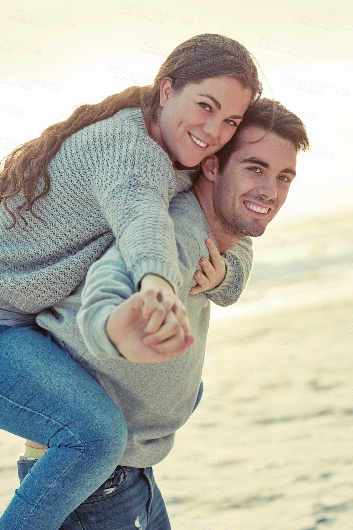 Buy stock photo Piggyback, smile and portrait of couple by beach for romantic vacation, travel or holiday together. Happy, love and young man and woman with fun for bonding by ocean or sea on tropical weekend trip.