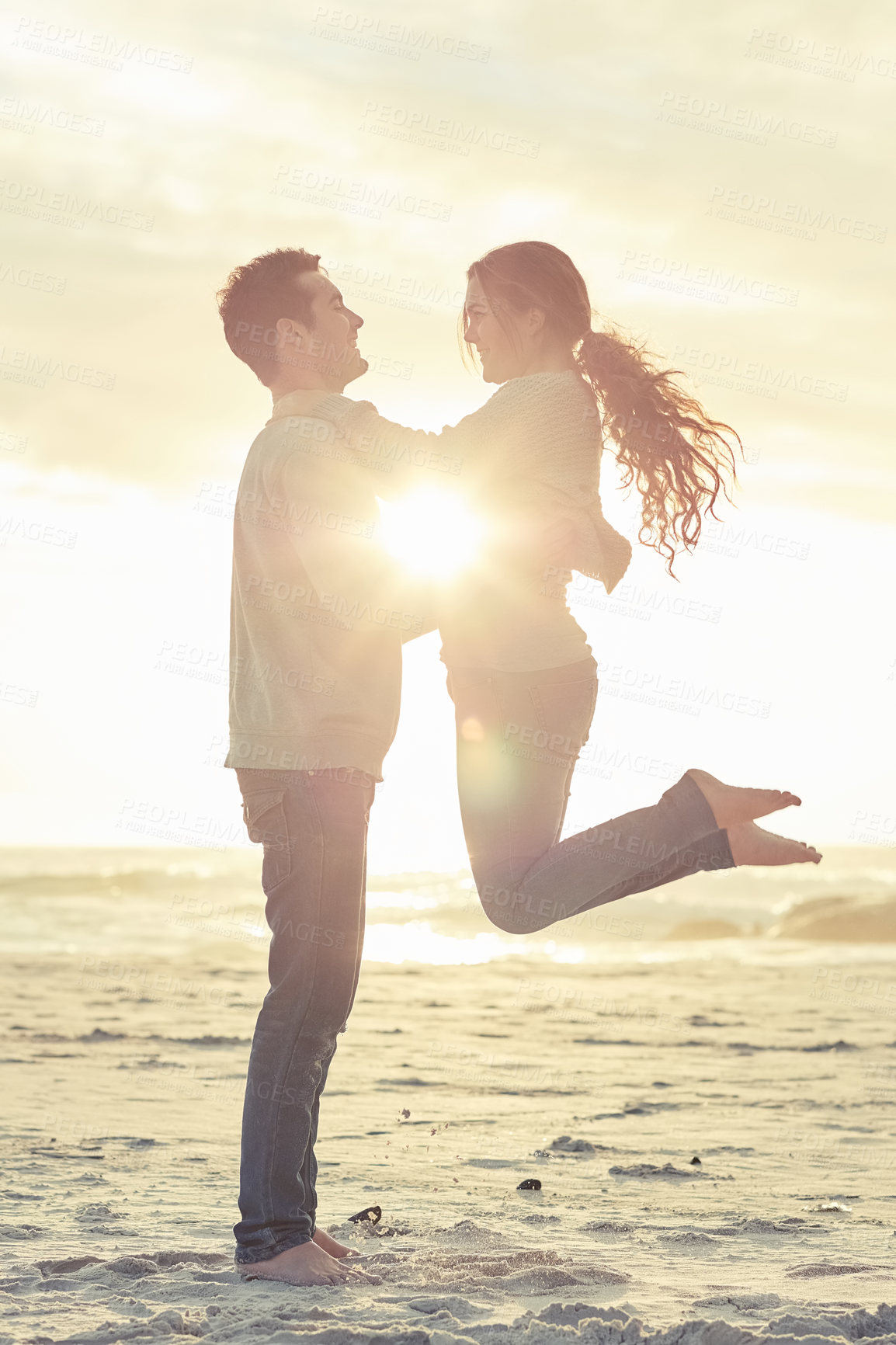 Buy stock photo Sunset, beach and man lift woman for romantic vacation, travel or holiday together with love. Happy, smile and young couple jump with fun for bonding by ocean or sea on tropical weekend trip.