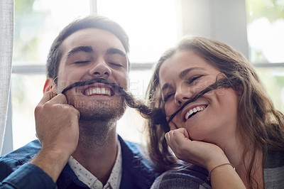 Buy stock photo Shot of a young couple enjoying a silly moment together while relaxing at home