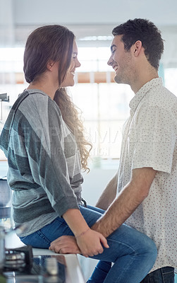 Buy stock photo Shot of a young couple having fun in the kitchen while relaxing at home