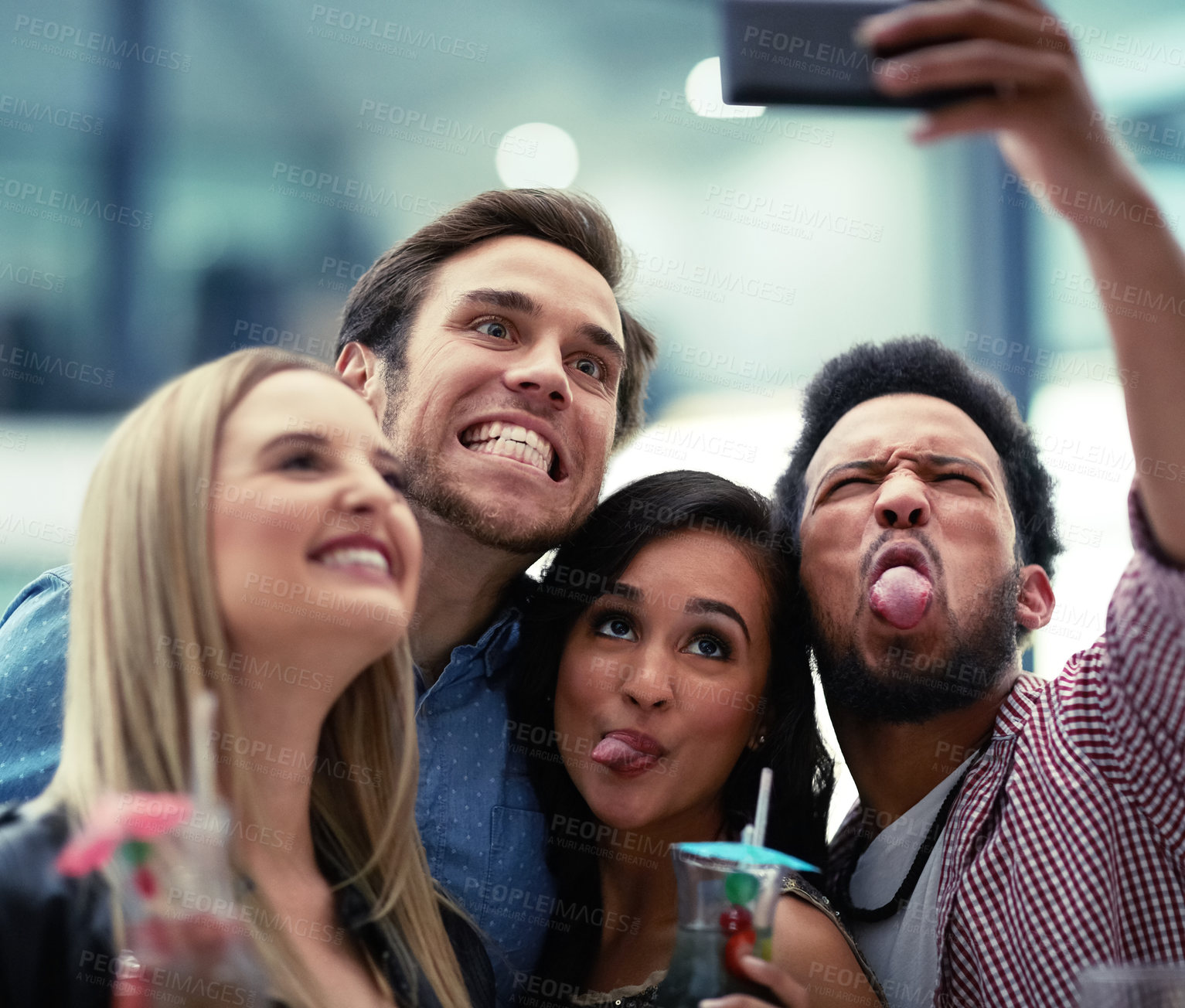 Buy stock photo Shot of a happy group of friends taking a selfie with a smartphone in a nightclub