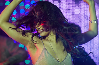 Buy stock photo Shot of a beautiful young woman dancing on her own in a nightclub