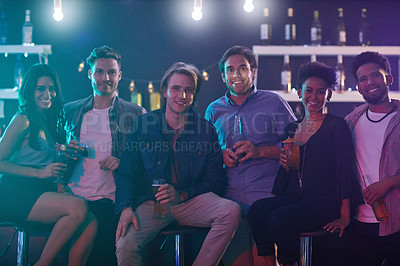 Buy stock photo Portrait of a group of happy friends enjoying drinks in a nightclub