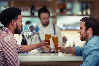 Buy stock photo Shot of two friends enjoying a beer together in a bar