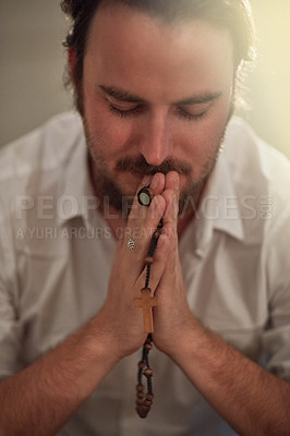 Buy stock photo Shot of a man holding a rosary and praying
