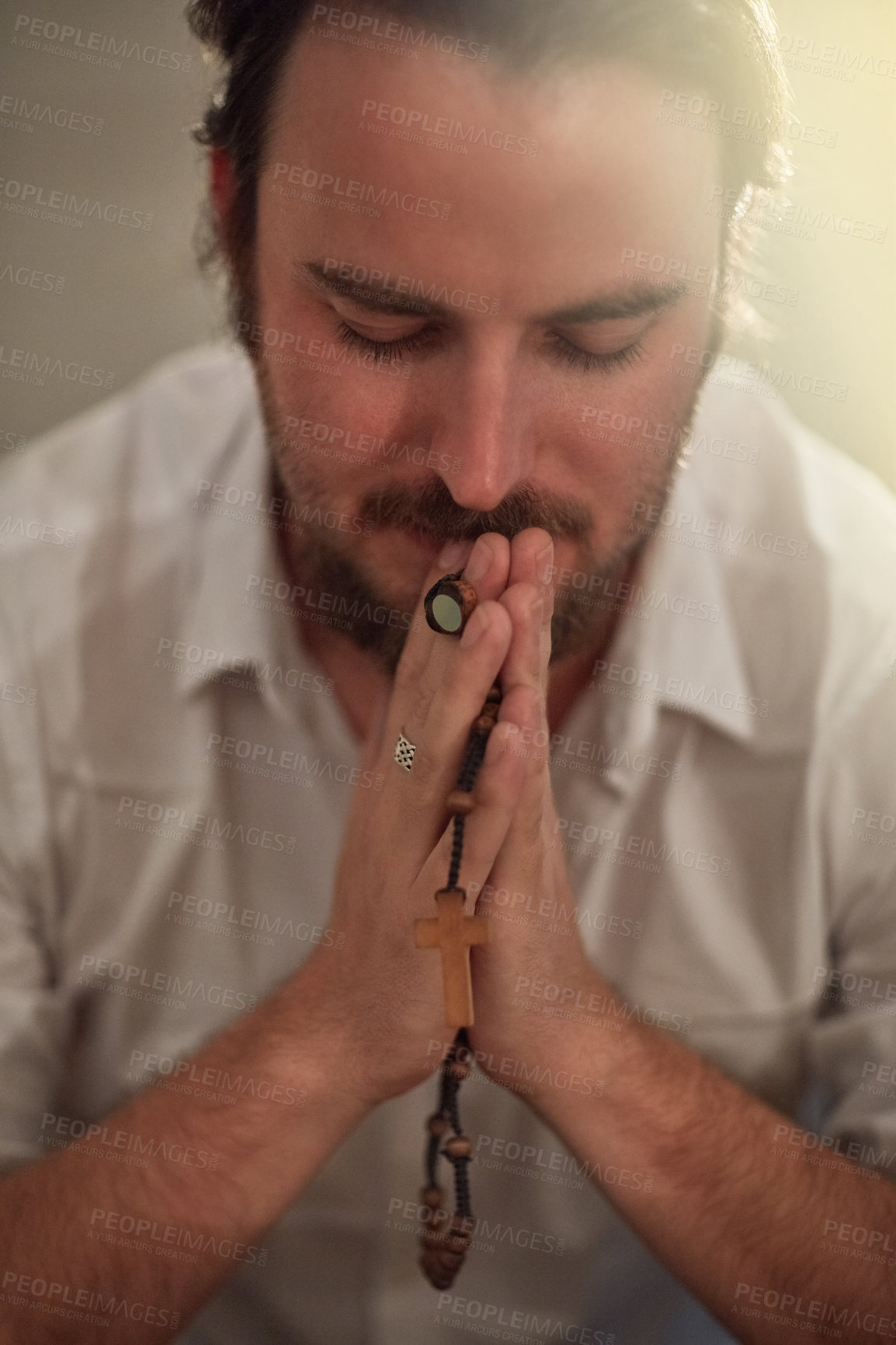 Buy stock photo Shot of a man holding a rosary and praying