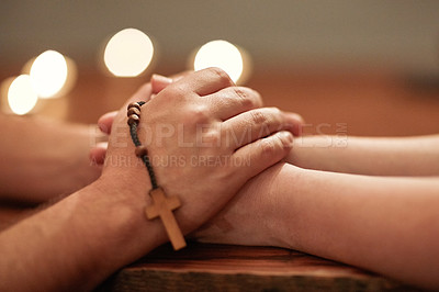 Buy stock photo Cropped shot of two people holding hands and praying together
