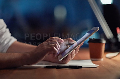 Buy stock photo Cropped shot of a businessman using a digital tablet at night in an office