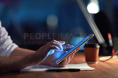 Buy stock photo Cropped shot of a businessman using a digital tablet at night in an office