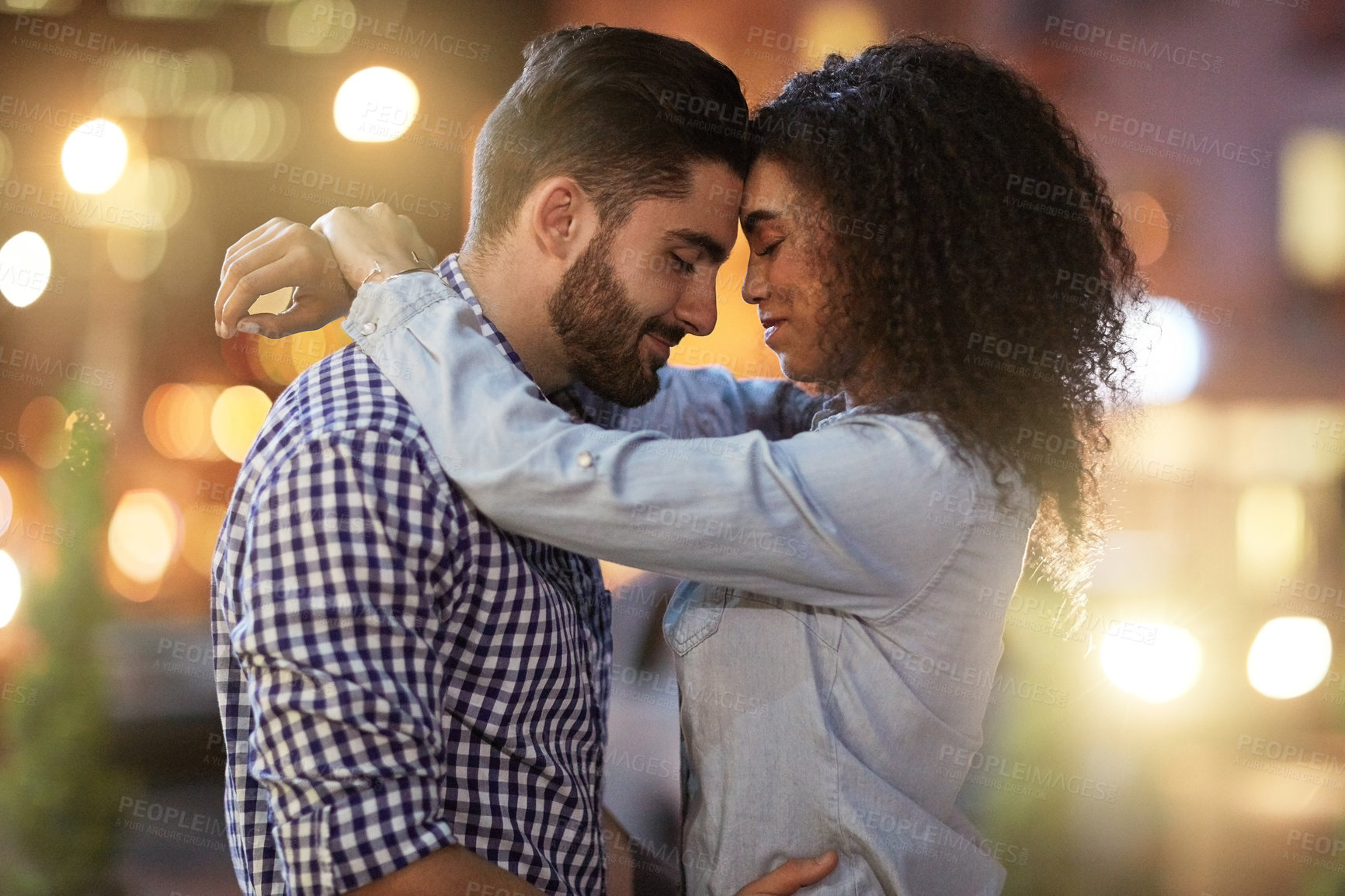 Buy stock photo Shot of an affectionate young couple out on a date in the city