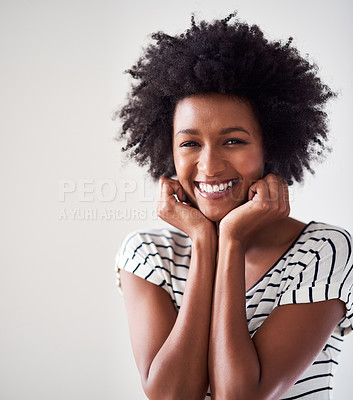 Buy stock photo Studio portrait of an attractive and happy young woman posing against a gray background