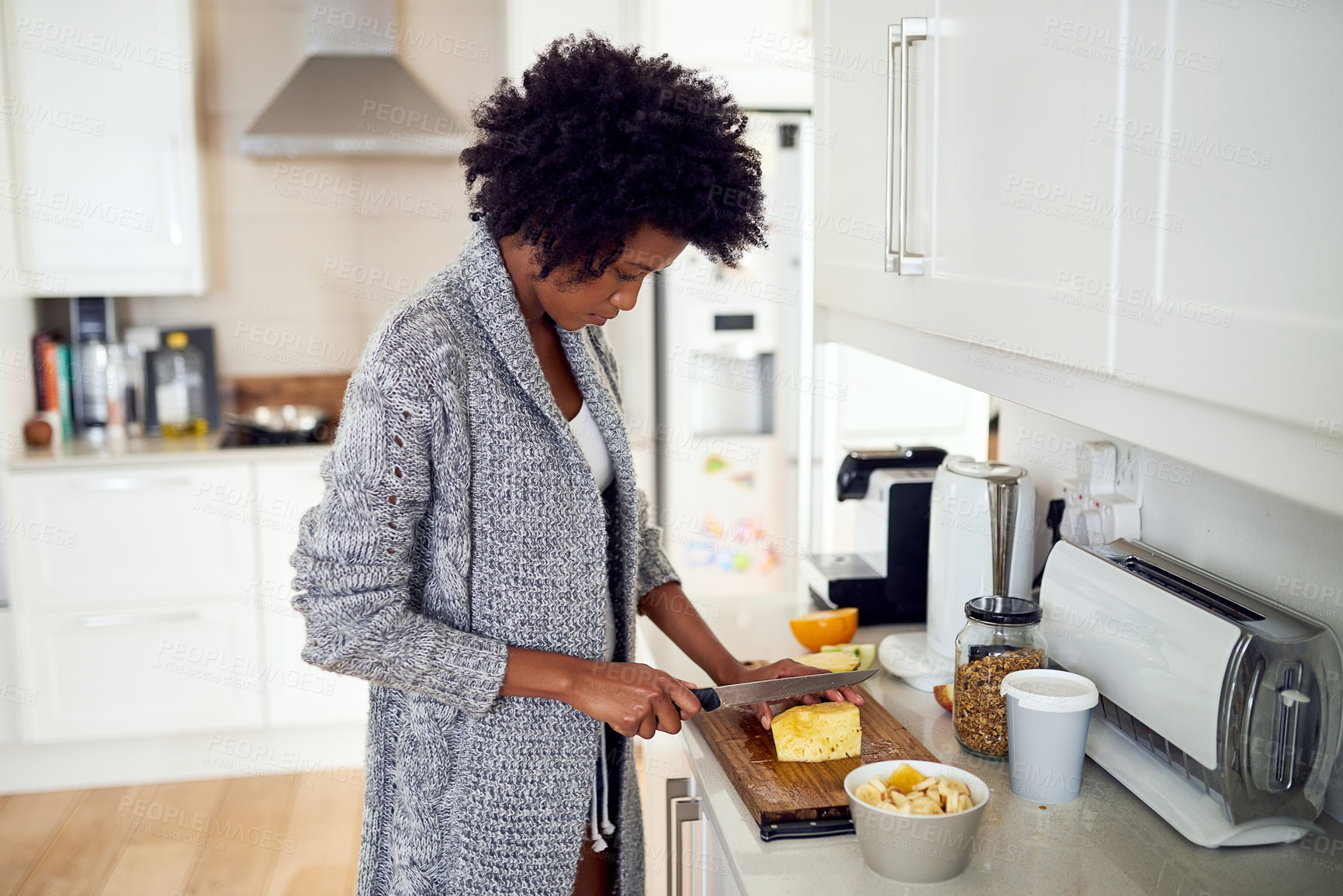 Buy stock photo Home, preparation and woman with pineapple in kitchen for eating, healthy and diet nutrition in morning. House, counter and female person with knife for cutting fruit, breakfast and meal ingredients