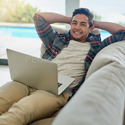 Buy stock photo Portrait of a relaxed young man using a laptop on the sofa at home