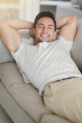 Buy stock photo Portrait of a happy young man relaxing on the sofa at home